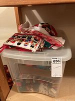 Photo showing clear plastic storage tote with lid, holiday stockings and a small figurine on top