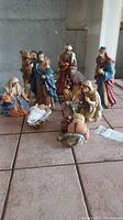 Full nativity set displayed on tiled floor showing all figurines in scene setup
