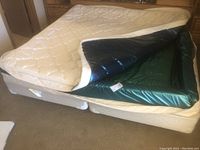 King size water bed mattress partially opened showing internal water bladder and baffles