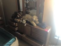 Oak dresser with six drawers shown from front with assorted stuffed toys on top