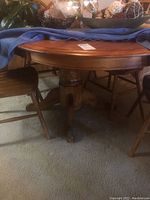 View of the oval oak dining table's top surface with polished finish and decorated with a blue cloth and glassware.