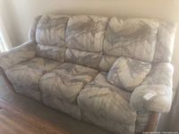 Front right angle view of the recliner sofa on hardwood floor with one pillow on right end.