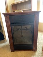 Front view of the portable electric fireplace heater with oak trim and black glass heating panel.