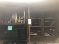 Kitchen upper cabinets containing Tupperware containers, zip bags boxes, glass jars, bowls, and kitchen gadgets.