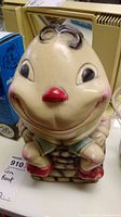 Front view of vintage Humpty Dumpty coin bank showing smiling face, red nose, and cracks in paint.