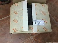 Box with two contact print frames inside, box partially open showing printed label with dimensions and quantity