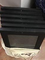Stack of six black contact print frames viewed from the side