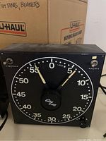 Front view of black Cra Lab darkroom timer Model 300 with large dial dial, pointer, switches and knob