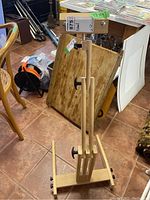 Full view of the easel from front showing adjustable wooden frame and clamp.