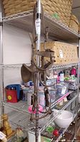 Full view of the vintage horse bridle hanging on metal shelving among household items.