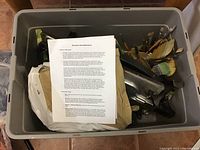 Full bin of encaustic paint supplies showing tools, brushes, metal pots, and white wax package