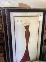First framed print of a red vintage dress on mannequin with black and silver wood frame and matting.