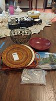 Full lot of 9 items including trays, bowls, and baskets arranged on floor.