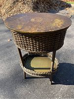 Full view of the antique wicker sewing basket stand showing oval top, woven basket sides, and lower shelf.