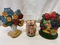 Front view of the two doorstops and the piggy bank showing detailed paintwork and weathering.