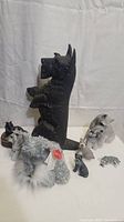 The full lot showing a variety of dog figures and the tall black cast iron door stop shaped as a standing dog.
