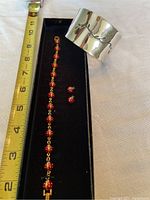 Full set including ladybug charm bracelet, stud earrings, and a measuring tape showing bracelet length.