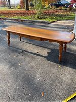 Full overview of the Kroehler maple coffee table with drawer, showing the entire piece outdoors on pavement.