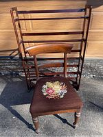Photo showing front of the wooden shelf stand and the wooden chair with needlepoint floral seat.