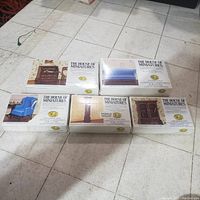 Six boxed miniature dollhouse furniture items from The House of Miniatures laid out on floor, showing product images and titles on the boxes.