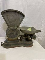 Front view showing heavy rust and patina on metal scale body, dial, and tray