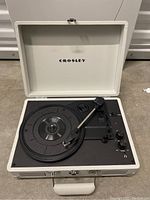 Full open view of the Crosley turntable in white case showing platter and tonearm.