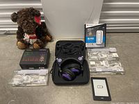 Full lot overview showing stuffed bear, Razer headphones, IKEA light strips, Motorola modem, Amazon Kindle