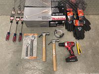Full lot of assorted tools shown: Makita crowbar in box, cordless drill, hammers, adjustable wrench set and wrenches, screwdrivers, gloves, and utility knife.