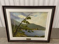 Frontal image of the framed oil painting showing the landscape scene with lake, trees, and mountains.