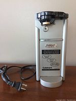 Full view of the Cuisinart electric can opener showing the main unit, power cord, and cutting gear.