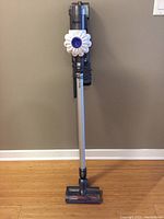 Full view of assembled vacuum on wall mount against wall