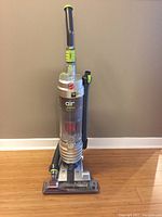 Full upright Hoover vacuum cleaner with canister and attached hose and tools, shown front view.