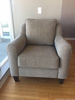 Front view of beige upholstered armchair showing overall condition