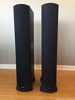 Front view of two tower speakers with fabric grilles installed