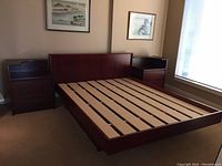 Angled front view showing queen bed frame headboard, side rails, footboard and slatted mattress support.