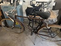 Full side profile of the vintage Schwinn bicycle showing brown frame, black saddle, and tires.