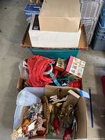 Boxes and containers filled with various Christmas tree ornaments, decorative pieces, and packaging boxes.