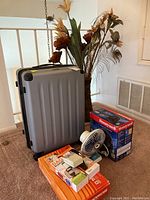 Photo showing suitcase, fans, faux flowers, and Thermophore heat pad in original packaging.
