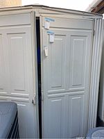 Front view of storage shed with slightly open double doors.