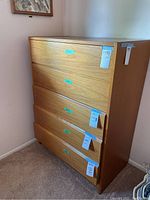 Front view of teak veneer dresser showing five drawers with recessed finger groove handles.