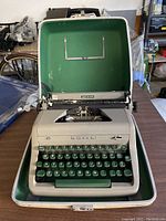 Front view of the vintage Royal manual typewriter inside the green lined carrying case, showing the keyboard and brand name.