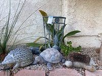 Wide shot of yard art group including two turtles, porcupine shoe cleaner and umbrella holder