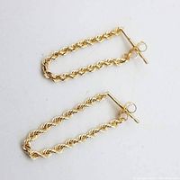Pair of yellow gold rope chain pierced earrings laid flat on white background showing their overall shape and texture.