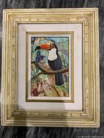 Full view of the framed painting showing the toucan on a branch with signature and textured oil paint surface.