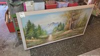 Full view of the framed oil on canvas landscape painting showing mountain, trees, cabin, and framed in light wood.