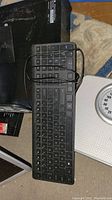 HP wired keyboard placed over a scale, cables visible