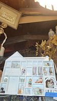 View of white decorative miniature shelf shaped like a house with various small porcelain figurines and collectibles inside compartments.