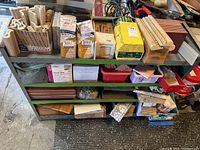 Shelving unit with multiple boxes and loose wood veneer tiles and grout packs.