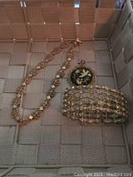 Image showing the necklace, pendant, and bracelet together on woven surface