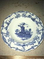 Top view of collector bowl showing detailed blue and white windmill design and scalloped edges.